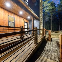 Deck railing along the side of the house at night