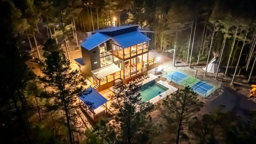 Night aerial of the house, pool and lit court