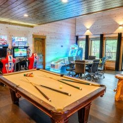 Pool table with racing arcade machines behind it