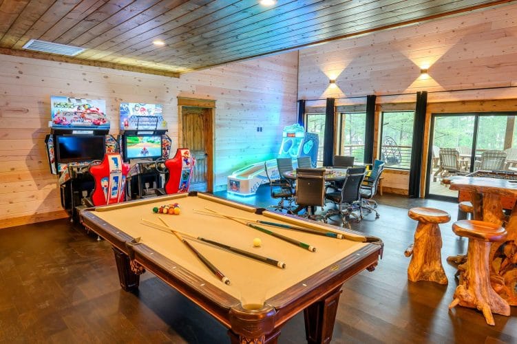 Pool table with racing arcade machines behind it