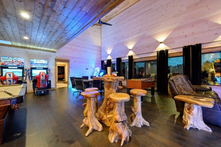 Game room with arcade machines, stump stools and high windows