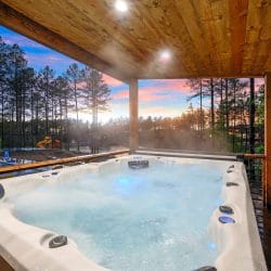 Hot tub steaming on a covered deck above the pond