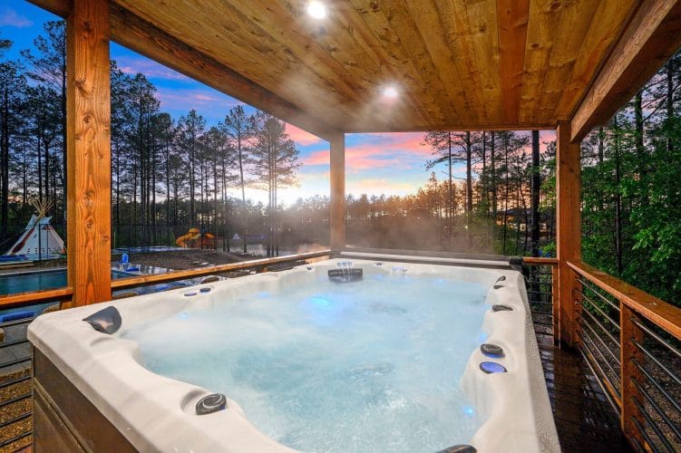 Hot tub steaming on a covered deck above the pond