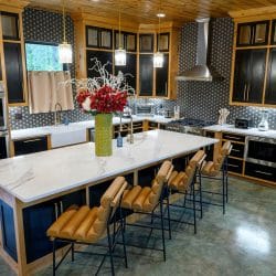 Large island with leather bar stools and double wall ovens
