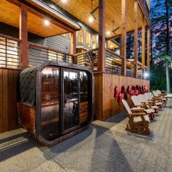 Outdoor wood sauna cabin beside rocking chairs on the pool deck