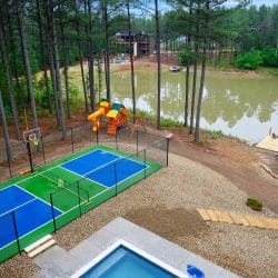 Aerial of the pickleball court, teepee, pond and playset