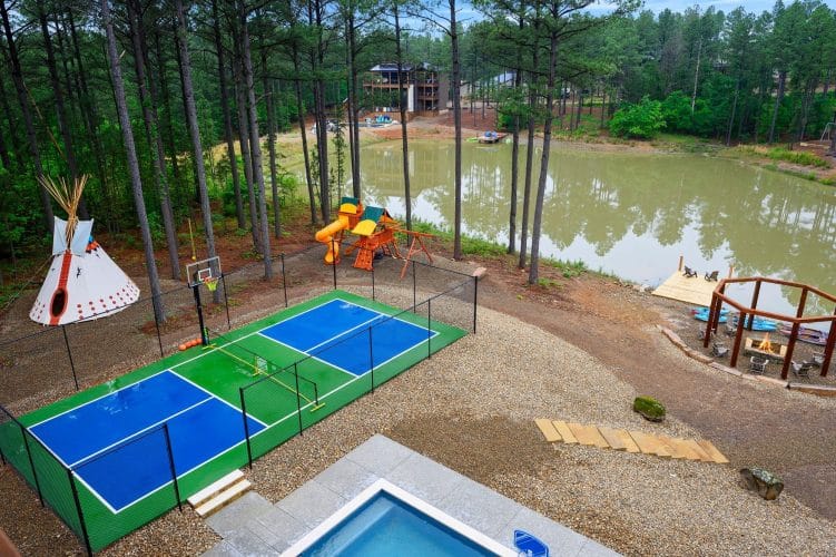 Aerial of the pickleball court, teepee, pond and playset