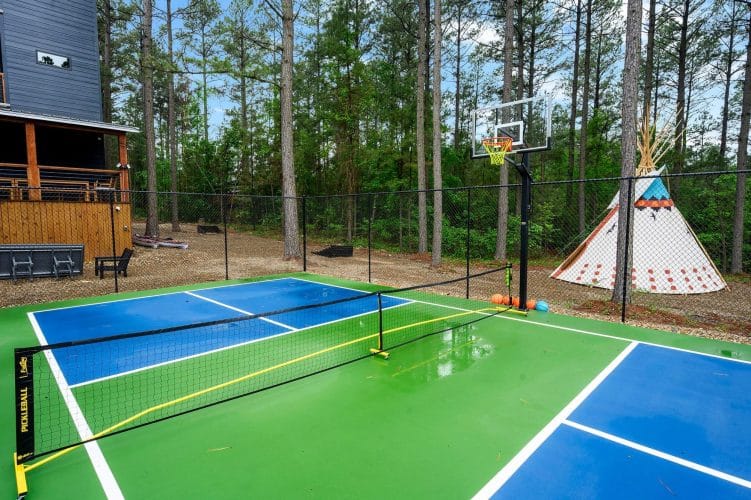 Court with a basketball hoop, net and the teepee behind