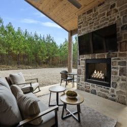 Outdoor sofa and chairs in front of the stone fireplace and TV on the patio