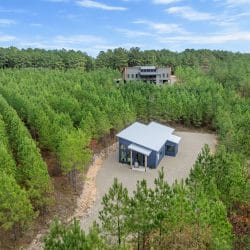 Aerial of the cabin in the pines with another house visible on the ridge
