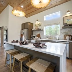 Island with place settings and stools under the vaulted wood ceiling