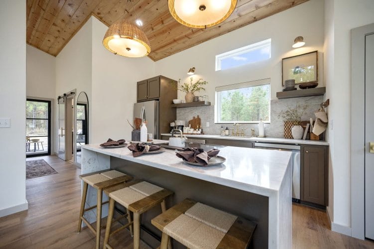 Island with place settings and stools under the vaulted wood ceiling