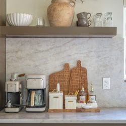 Coffee station on a stone backsplash with two coffee makers and cutting boards