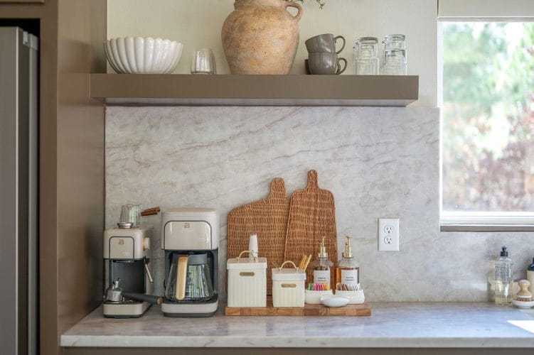 Coffee station on a stone backsplash with two coffee makers and cutting boards