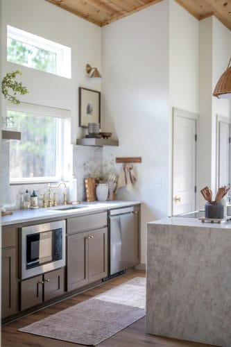 Kitchen sink with brass faucet, dishwasher and floating shelf