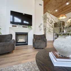 Fireplace with two gray armchairs under the TV
