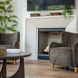 Close view of the fireplace and a gray armchair