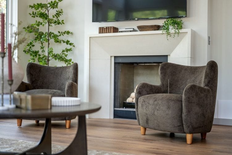 Close view of the fireplace and a gray armchair