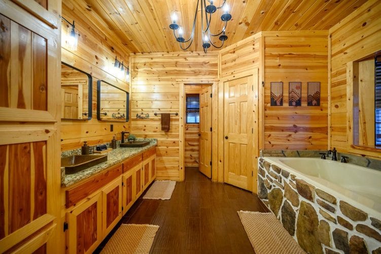 Bathroom with a double granite vanity and a stone-surround tub