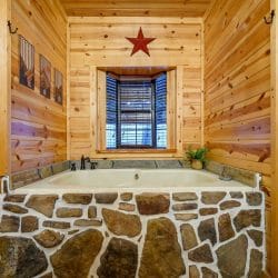 Soaking tub with a fieldstone surround under a window
