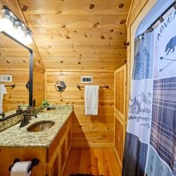 Vanity with a black-framed mirror and a patterned shower curtain