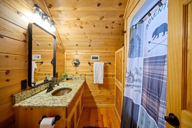 Vanity with a black-framed mirror and a patterned shower curtain