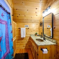 Vanity with a black-framed mirror and a colorful shower curtain