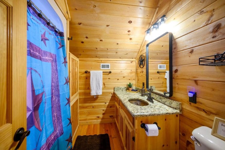 Vanity with a black-framed mirror and a colorful shower curtain