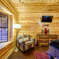 Bedroom with an armchair, dresser, floor lamp and wall TV