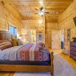 Foot of the bed with an open door to the hallway and bath
