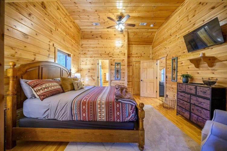 Foot of the bed with an open door to the hallway and bath