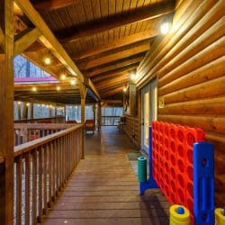 Giant Connect Four game on the deck with string lights above