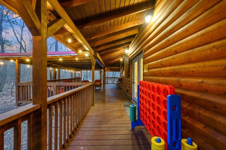 Giant Connect Four game on the deck with string lights above