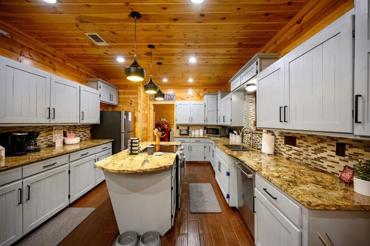 Kitchen with gray cabinets, granite counters and a center island