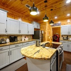 Island with a cooktop built in, pendant lights and gray cabinets