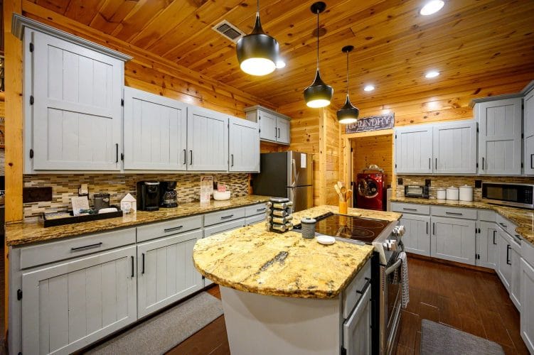 Island with a cooktop built in, pendant lights and gray cabinets