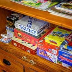 Shelf of board games including Sequence, Catan and Taboo
