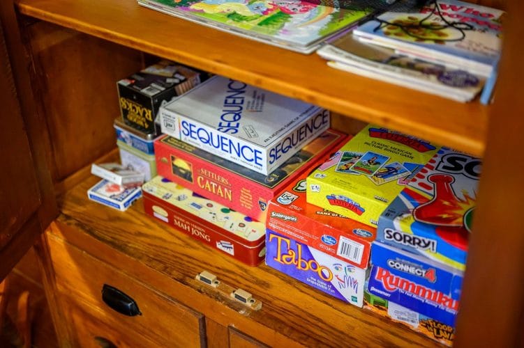 Shelf of board games including Sequence, Catan and Taboo