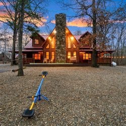 Seesaw in the gravel yard with the cabin's stone chimney in the background