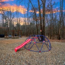 Blue climbing dome with a red slide in the yard