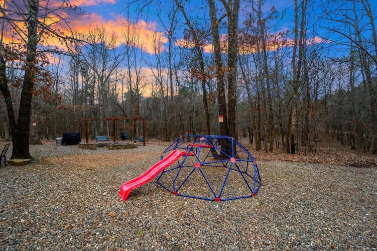 Blue climbing dome with a red slide in the yard