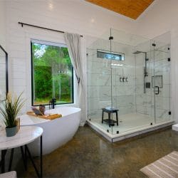 Bathroom with a freestanding tub, a glass walk-in shower and a robe on a hook