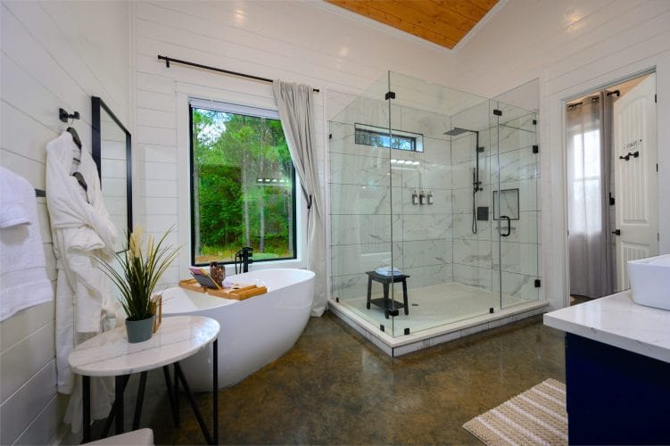 Bathroom with a freestanding tub, a glass walk-in shower and a robe on a hook