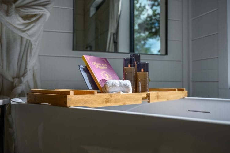 Close view of the bath tray with a book and candles
