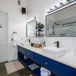 Navy double vanity with two vessel sinks and a long mirror