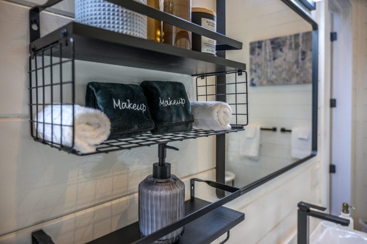 Shelf with rolled washcloths, a mirror and a soap dispenser