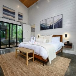 King bed seen from the side, with sliding glass doors to the deck