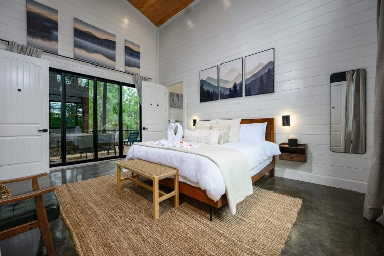 King bed seen from the side, with sliding glass doors to the deck
