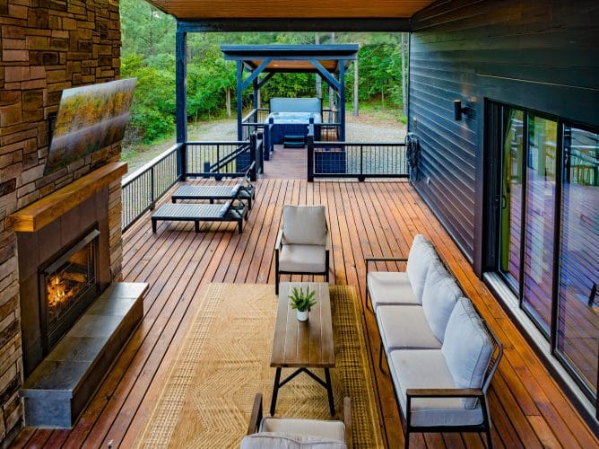 Covered deck with a gas fireplace, an outdoor sofa and lounge chairs