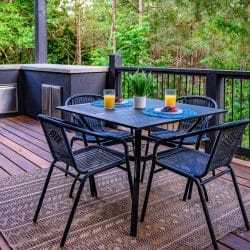 Four-chair patio table with orange juice, beside the built-in grill